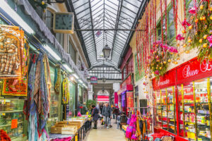 It features a unique glass roof that covers one side of the arcade, filling the space with natural light and creating a charming atmosphere.