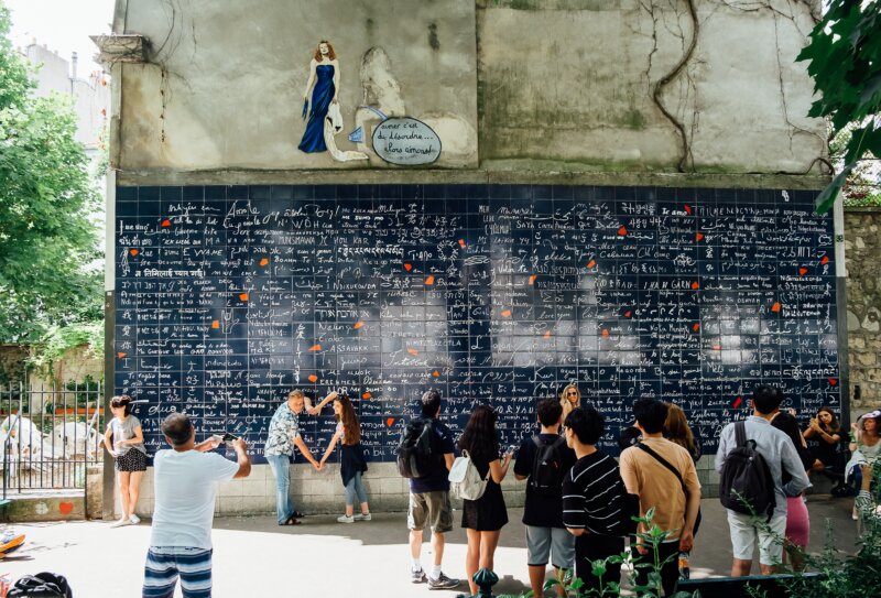 Tourists taking pictures in front of the famous Le mur des je t'aime in Paris