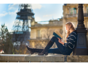 Woman reading book near Eiffel Tower in Paris