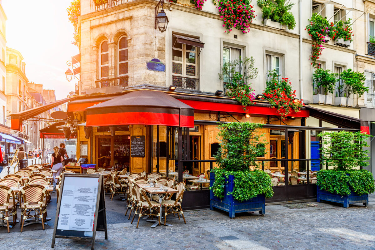 Cozy street with tables of cafe in Paris, France. Architecture and landmark of Paris