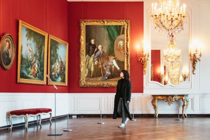 Tourist viewing paintings inside the Versailles palace