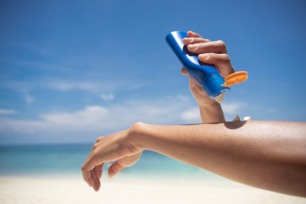 Woman applying sunblock on her hands