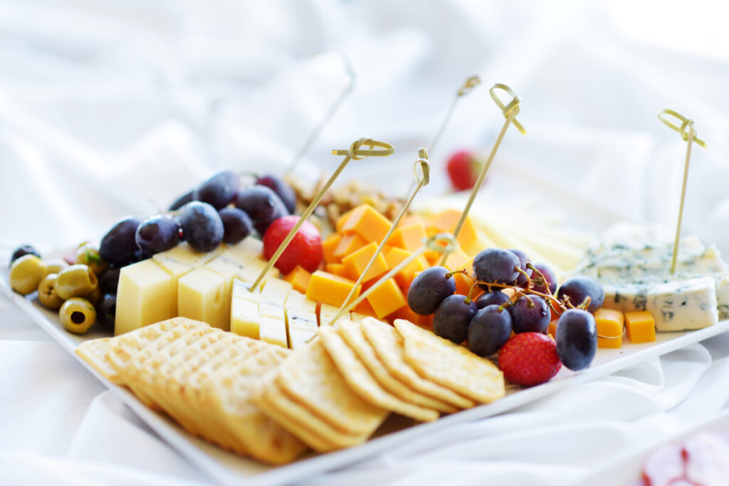 Close-up of charcuterie board with different cheese, fruits, olives, and crackers