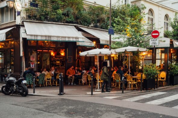 Charming Parisian street bustling with people enjoying coffee at outdoor café tables