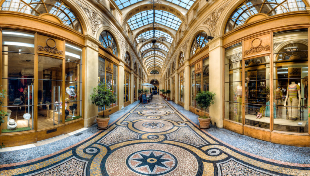 Interior view of Galerie Vivienne, highlighting its elegant design, upscale shops, and stunning architectural features