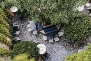 Picturesque garden with lush greenery, winding pathways, and quaint seating areas at Hôtel Bienvenue.