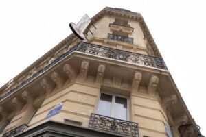 The exterior facade of Hotel & Spa Saint-Jacques, featuring elegant architectural details and flower-adorned balconies against a clear blue sky.