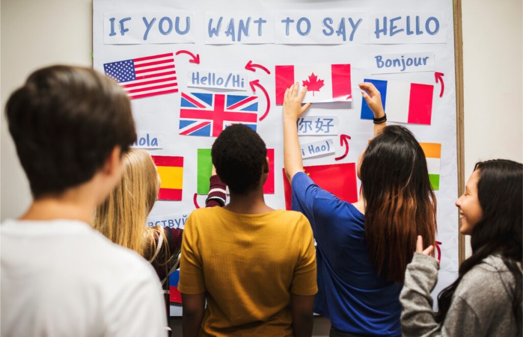 Teenagers interacting with a national flags board, showcasing their diverse backgrounds at a language school