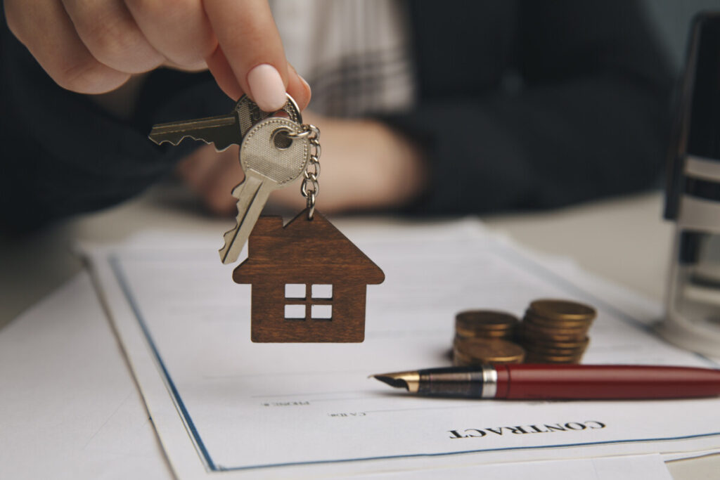 Hand handling keys and a piece of mortgage contract