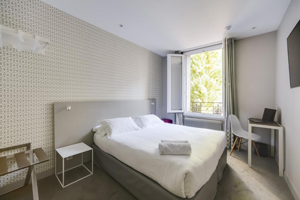 Parici Hôtel Boulogne Billancourt's rooms offer a perfect blend of comfort and contemporary style, featuring modern furnishings, cozy bedding, and thoughtful amenities.