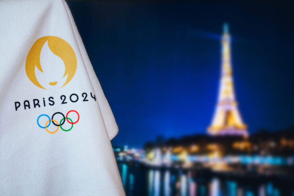 Paris Olympics 2024 Sign with Eiffel Tower at night as a background