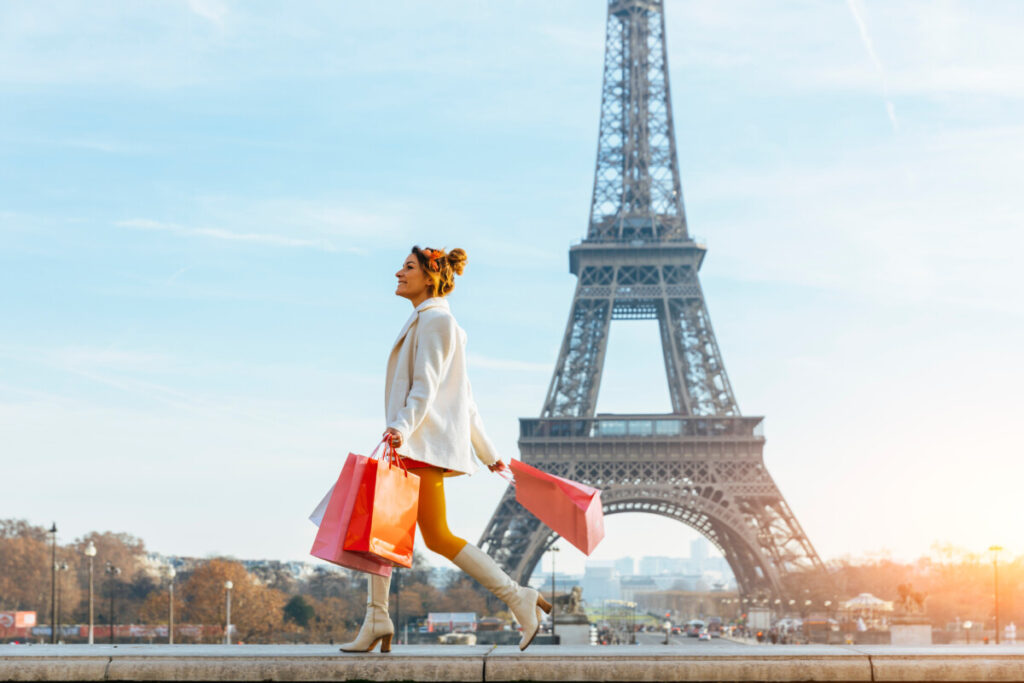 Young woman with shopping bags in Paris with Eiffel tower in the background