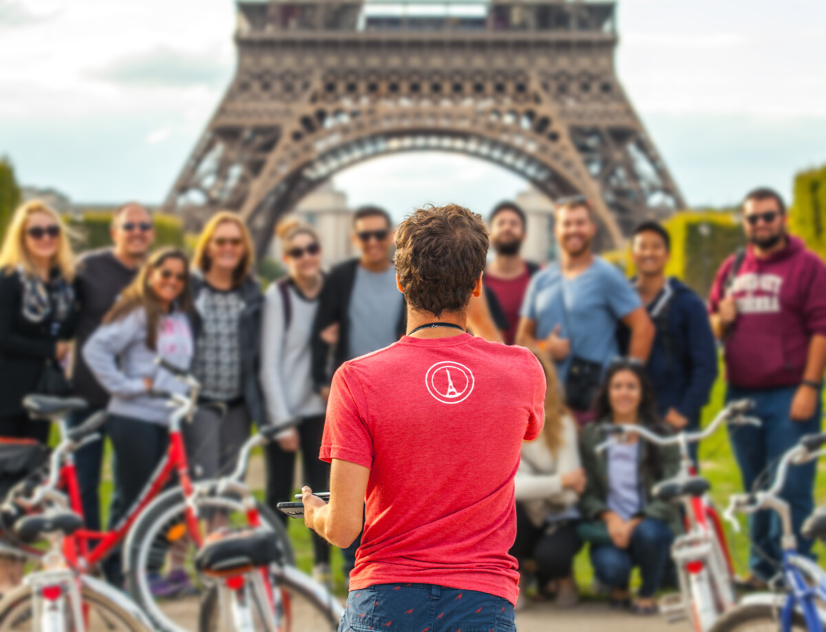 Man photographs big group of tourists against Eiffel Tower in Paris. France.