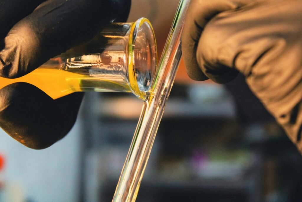 Man pouring and mixing perfume liquid on a glass 