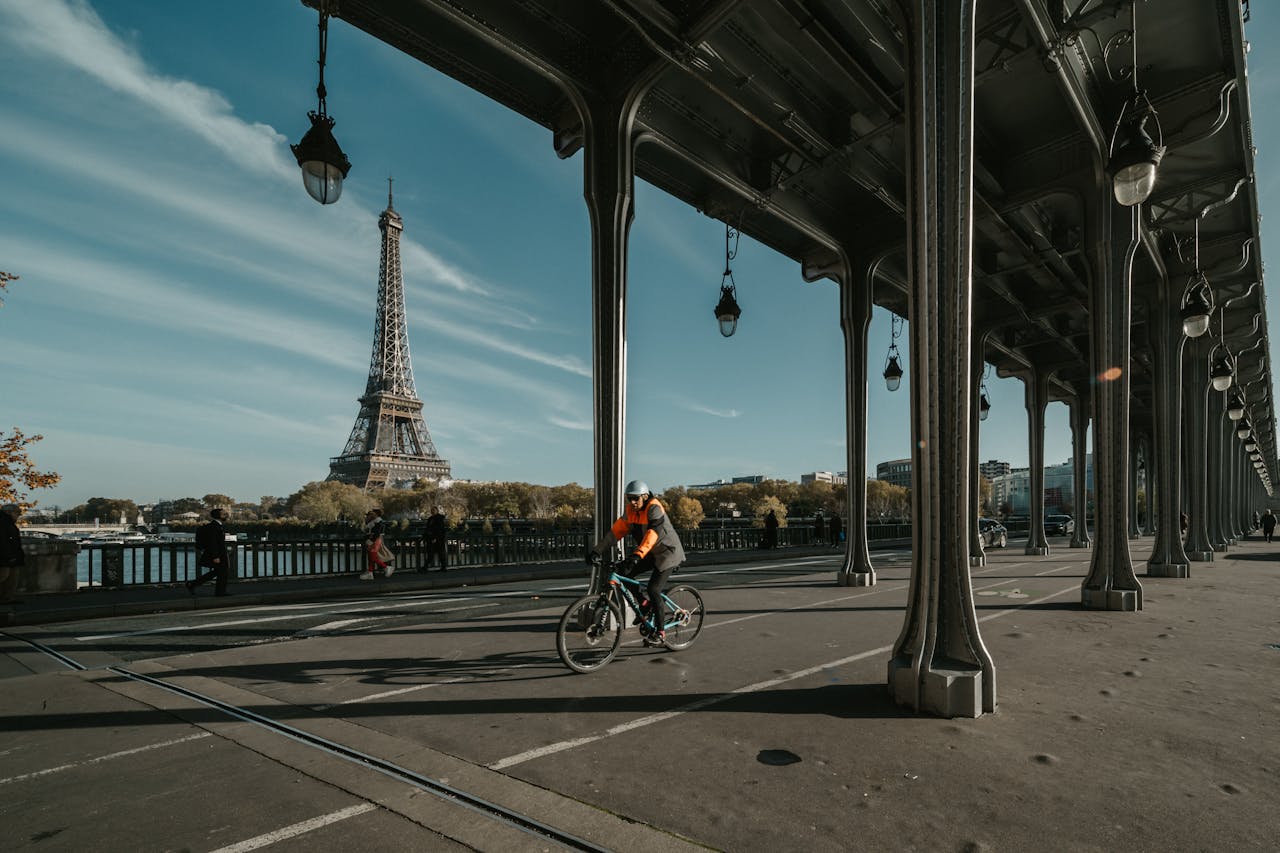 Man biking in Pont de Bir-Hakeim Arch Bridge with Eiffel Tower on the back