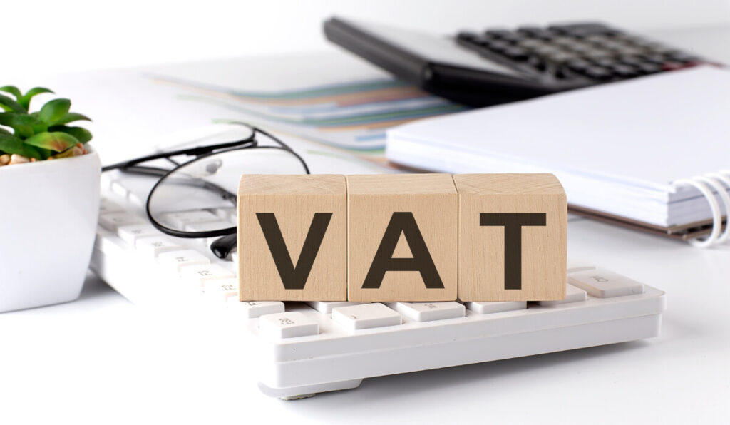 Value Added Tax letters VAT written on a wooden cube on a white keyboard